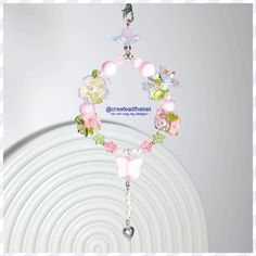 a bracelet with flowers and beads hanging from it's end on a white plate