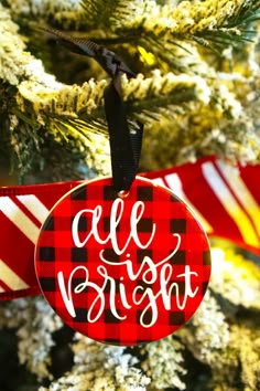 a red and black ornament hanging from a christmas tree that says, all right