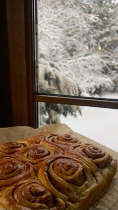 a pastry sitting on top of a piece of wax paper next to a snow covered window