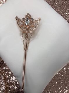 a white pillow with a gold and crystal brooch on it's lapel