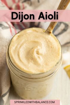 a mason jar filled with dijon aioli on top of a table