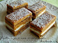 four pieces of cake on a plate with powdered sugar and crumb toppings