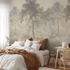 a bed sitting in a bedroom next to a wall with trees on it and birds flying above