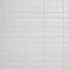 a white tiled wall and floor with no one in the room or someone standing on it