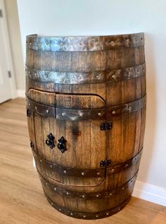 a wooden barrel sitting on top of a hard wood floor next to a white wall