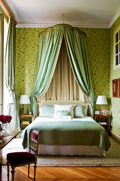 a bedroom with green walls and curtains on the windowsills is pictured in this image