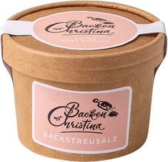 an open brown bucket with pink label on the lid and white ribbon around the top