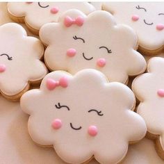 decorated cookies with pink and white icing are arranged in the shape of clouds