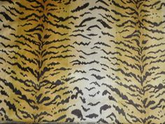 a tiger print rug with black and yellow stripes on it's sides, in front of a wooden table