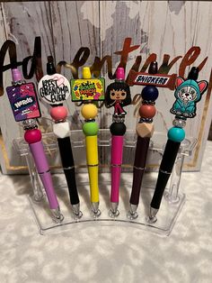 several different colored pens are in a clear holder with magnets on the top and bottom