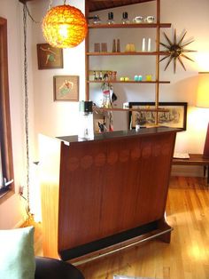 a living room filled with furniture and a wooden bar in front of a large window