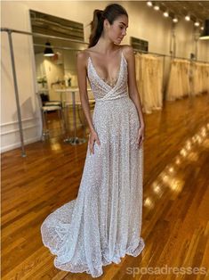 a woman in a white dress standing on a wooden floor