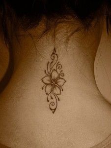 a woman's back neck with a flower tattoo on the upper part of it