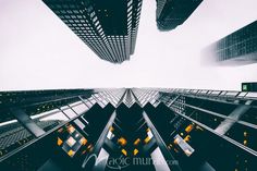 looking up at skyscrapers in the city from ground level, with yellow lights on them