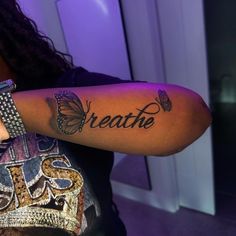 a woman with a butterfly tattoo on her arm that says breathe and butterflies are flying around