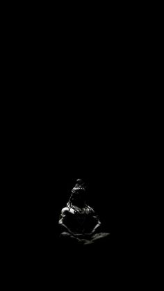 a black and white photo of a person sitting in the dark with their head down