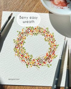 an image of berry easy wreath on paper with paintbrushes and watercolor paints