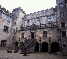 an old castle with stairs leading up to the second floor and two story windows on each side