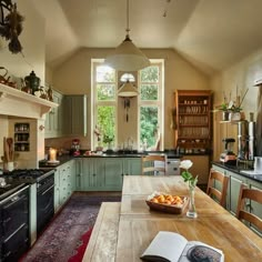 an open book is sitting on a table in the middle of a large kitchen with lots of counter space