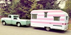 an old truck towing a pink and white trailer