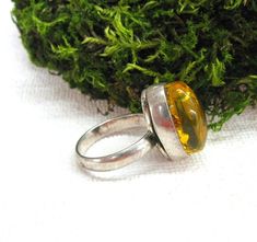 Baltic Amber Statement Ring in perfect vintage condtion. Natural yellow amber oval cabochone is set in silver plated ring. Women's size 9 ( US ), J 1/2 ( UK and Australia ), 19 ( Europe ). The stone measurements: 12 mm wide, 18 mm long and 9 mm thick. You can see the ring from all sides, please view all 5 photos. This eye catching cocktail ring is made for a woman with large finger size. Please note: this jewelry piece is one of a kind, the size is not adjustable. This collectible ring will make Vintage Cabochon Rings For Gifts, Vintage Cabochon Rings As Gift, Handmade Amber Oval Cabochon Rings, Vintage Oval Cabochon Ring For Gift, Vintage Oval Cabochon Ring As A Gift, Vintage Oval Cabochon Ring As Gift, Yellow Oval Cabochon Ring For Gift, Handmade Oval Amber Rings, Handmade Retro Rings As Gift