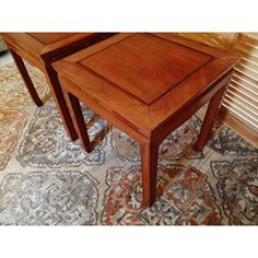 two wooden tables sitting on top of a rug