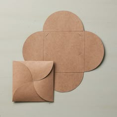 two pieces of brown paper sitting next to each other on top of a white surface