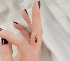 a woman's left hand with a small tattoo on the middle finger and an anchor