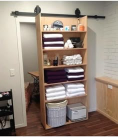 the shelves in this bathroom are filled with towels