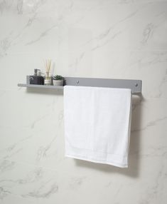 a white towel hanging on the wall next to a shelf