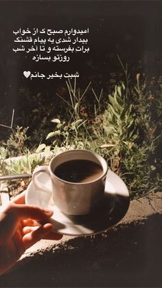 a cup of coffee sitting on top of a white saucer next to a hand