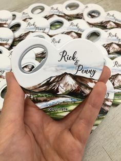 a person holding up a button that says, rick and penny with mountains in the background