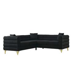 a black sectional couch with gold legs and pillows on it's back end, facing the camera