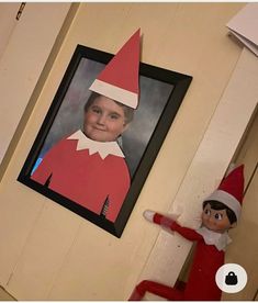 an elf is hanging on the wall next to a picture