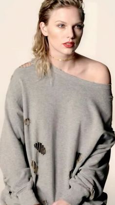 a woman with blonde hair wearing a grey sweater