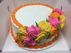 there is a cake with flowers on it in the shape of a circle and orange border