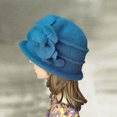 a doll wearing a blue hat with flowers on it's brimmed top