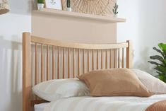 a wooden headboard with pillows on top of it in front of a wall mounted clock