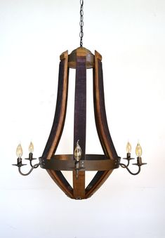 a wooden chandelier with five lights hanging from it's sides and wood casing