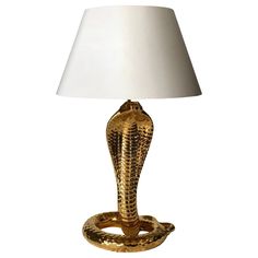 a lamp with a snake on it and a white lampshade over the top