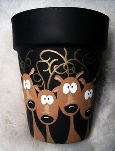 a black cup with three reindeer faces on it