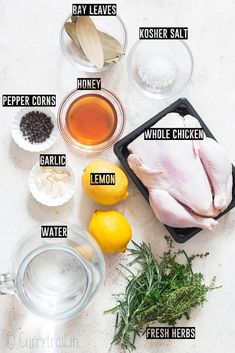 ingredients to make chicken broth laid out on a counter top with lemons, herbs and seasonings