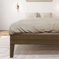 a bed sitting on top of a white rug next to a wooden headboard and foot board