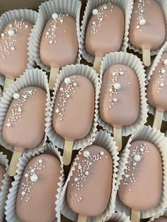 chocolate covered desserts with white sprinkles are arranged in rows on sticks