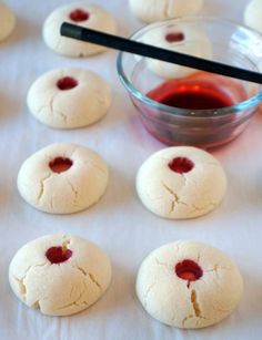 several cookies with jam in a bowl and on the table