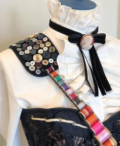 a mannequin is adorned with buttons and ribbons