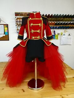 a red and black tulle skirted dress on a mannequin head stand