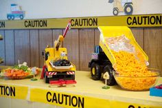 a table topped with toys and construction vehicles next to a bowl of food on top of it