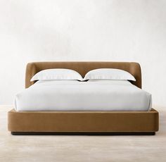 the bed is made with white sheets and pillows on it's headboard,