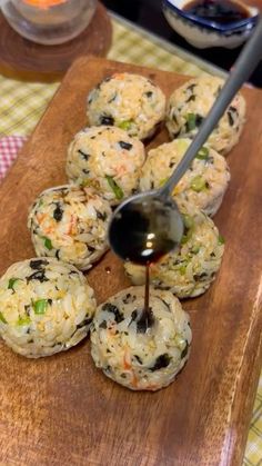 a spoon drizzling sauce onto some food on a cutting board with other foods